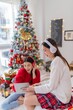 © StockPhotoRepublic - Two young asian female lady friends in a room listening to new songs on their headphone via their digital tablet celebrate Christmas together