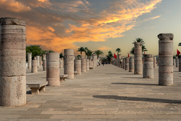 People walking around the medieval columns next to the Hassan tower in Rabat, Morocco