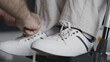 © Synthex - Close-up of nurse tying shoelaces of person in wheelchair, assisted living facility
