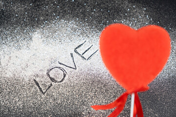 Valentine's Day, red loving heart on a black background with sequins and the text of love.