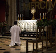 curé en train de prier devant l'autel d'une église