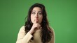 © Robert Peak - Portrait of hipster woman 20s looks around put finger to lips shh quiet isolated on green screen background studio portrait