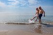 © alex.pin - coppia di anziani al mare giocano sula riva schizzando e calciando l''acqua