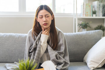 Wall Mural - Sick, hurt or pain asian young woman, girl with sore throat, cough have a fever, flu and sneezing nose, runny sitting on sofa bed at home. Health care person on virus seasonal.