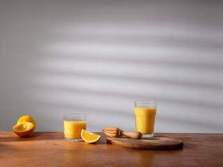 A glass of freshly pressed orange juice on the kitchen counter. Morning atmosphere, sunlight