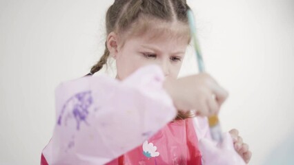 Sticker - Little girl painting paper mache figurine at homeschooling art class.