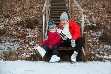 grandmother and child granddaughter  ice skating on a frozen lake  in winter nature. Enjoying the little things. Winter Vibes. christmas holiday.