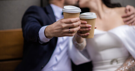 Wall Mural - hands of bride and groom with rings. bride and groom in a cafe. wedding bouquet table. bride and groom hold each other's hands. Wedding rings. Loving couple in a cafe. hot tea for lovers