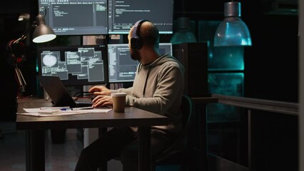 Database programmer writing html code on multiple screens, displaying cloud computing algorithm at night. Programming online network with coding language to develop new interface. Handheld shot.