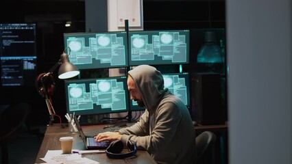 Dangerous IT coder working on security breach, creating cyber attack on data server. Hacking computer system and software, breaking database security and stealing program information. Handheld shot.