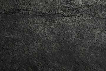 Texture of dark grey stone surface as background, closeup