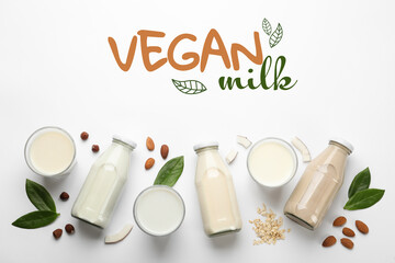 Different organic vegan milks and ingredients on white background, flat lay