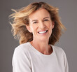 © K Davis/peopleimages.com - Skincare, beauty and portrait of happy old woman, smile on face and hair blowing. Wellness, beauty products and confident senior female pose for anti aging cosmetics and dermatology care in studio