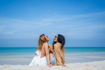 Wall Mural - People spending time at the beautiful beach,Happy female friends enjoy activity on holiday travel vacation at the sea,Having Fun,Summer Lifestyle,Nice weather in travel and holiday concept.