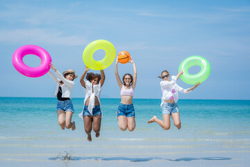 Wall Mural - Two attractive girls jumping on the beach,Having Fun,Summer Lifestyle.