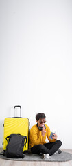 Wall Mural - Male traveler with yellow suitcase passport and tickets has nausea vomit fingers in mouth sitting on isolated white background