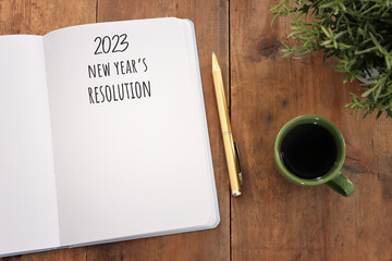 Wall Mural - Business concept of top view 2023 new resolution list with notebook over wooden desk