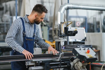 Wall Mural - Worker in uniform working on machine in PVC shop indoor