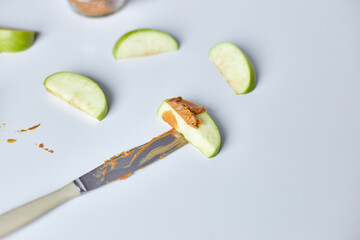 Green slices apples with peanut butter on white background, healthy snack, nutrition food, diet