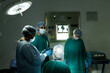 © wavebreak3 - Diverse group of surgeons in discussion, using tablet in operating theatre before operation