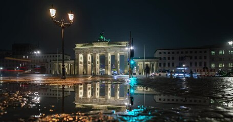 Wall Mural - Brandenburger Tor und Reflexion in einer Pfütze nach Regen am Abend in Berlin. Time Lapse.
