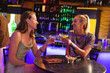 © Wavebreak Media - Two happy caucasian female friends drinking at a table, making a toast in the bar of a nightclub