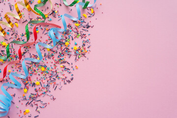 Canvas Print - Top view of serpentine and sprinkles on pink background with copy space.