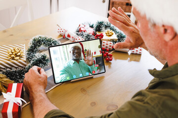 Sticker - Senior caucasian man having christmas video call with senior african american man