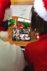 Wall Mural - Diverse couple having christmas video call with diverse people