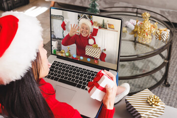 Canvas Print - Caucasian woman with santa hat having video call with happy caucasian woman