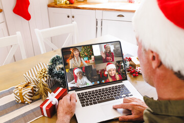 Wall Mural - Caucasian man with santa hat having video call with happy caucasian friends