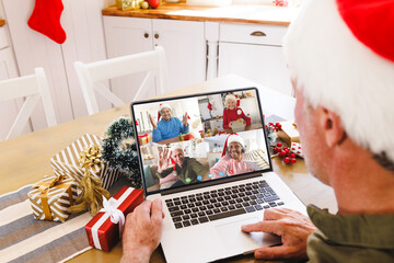 Poster - Caucasian man with santa hat having video call with happy diverse friends