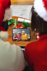 Poster - Diverse couple with christmas decorations having video call with happy diverse couple