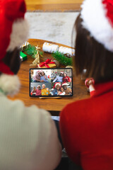 Poster - Diverse couple with christmas decorations having video call with happy diverse friends