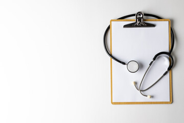 Composition of stethoscope with clipboard on white background with copy space