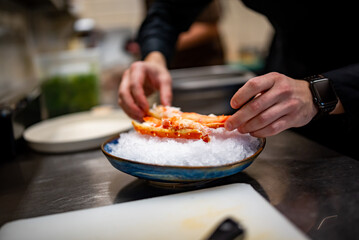 chef cooking crab legs with caviar on kitchen