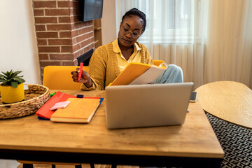 Wall Mural - Young African American female student studying at home.