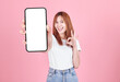 Asian young woman showing smart phone with blank screen , white screen for Mobile App Advertising isolated on pink background ,Cell phone display Mock Up Image.