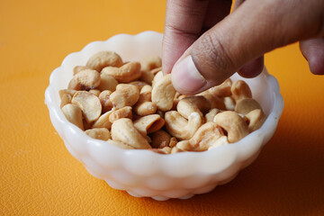 Wall Mural - hand pick a cashew nut from a small bowl