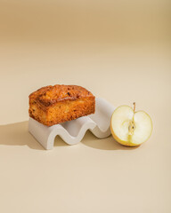 Poster - Creative serving of apple cake with green apple close up on beige background