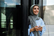 © Drobot Dean - Muslim woman using smartphone while standing outdoors