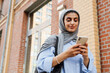© Drobot Dean - Muslim woman using smartphone while standing outdoors