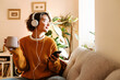 © Drobot Dean - Young woman listening music and using cellphone while drinking coffee