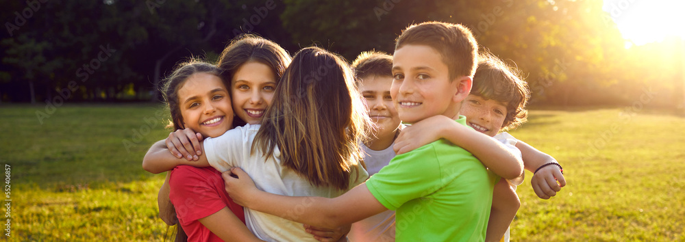 Happy friends hugging in green summer park. Group of children having ...