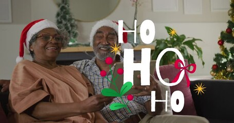 Poster - Animation of ho ho ho text over senior african american couple wearing santa hats