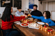 © Drobot Dean - Multi generation family clinking glasses while having christmas dinner