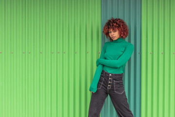 Wall Mural - urban girl on the street with green wall background