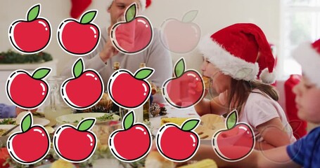 Poster - Animation of apples over caucasian family with santa hats having christmas dinner