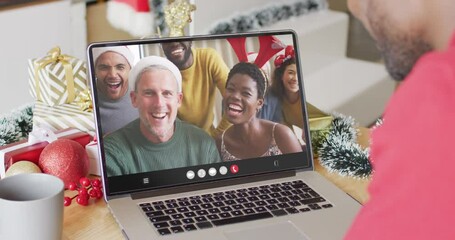 Poster - African american man with santa hat having laptop video call with happy diverse friends