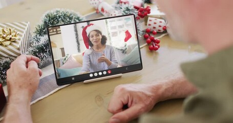 Poster - Caucasian man with christmas decorations having tablet video call with biracial woman